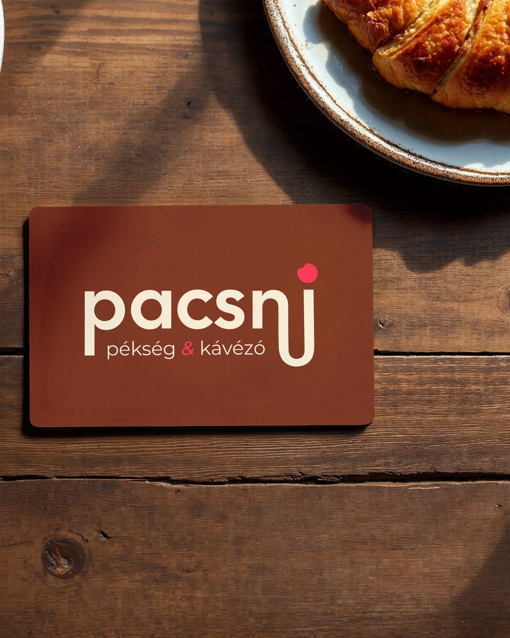 Pacsni Bakery logo on a card